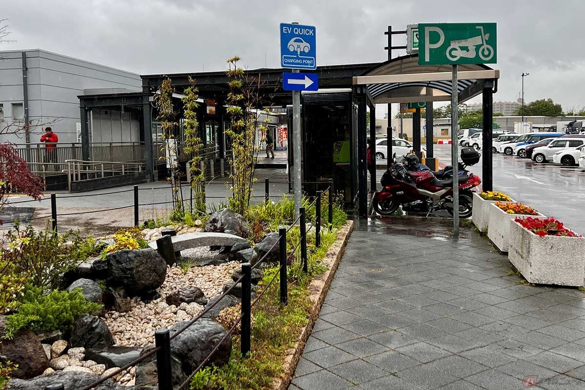 日本庭園的な植え込みの近くに屋根が設置された2輪専用の駐車スペースが確保されている