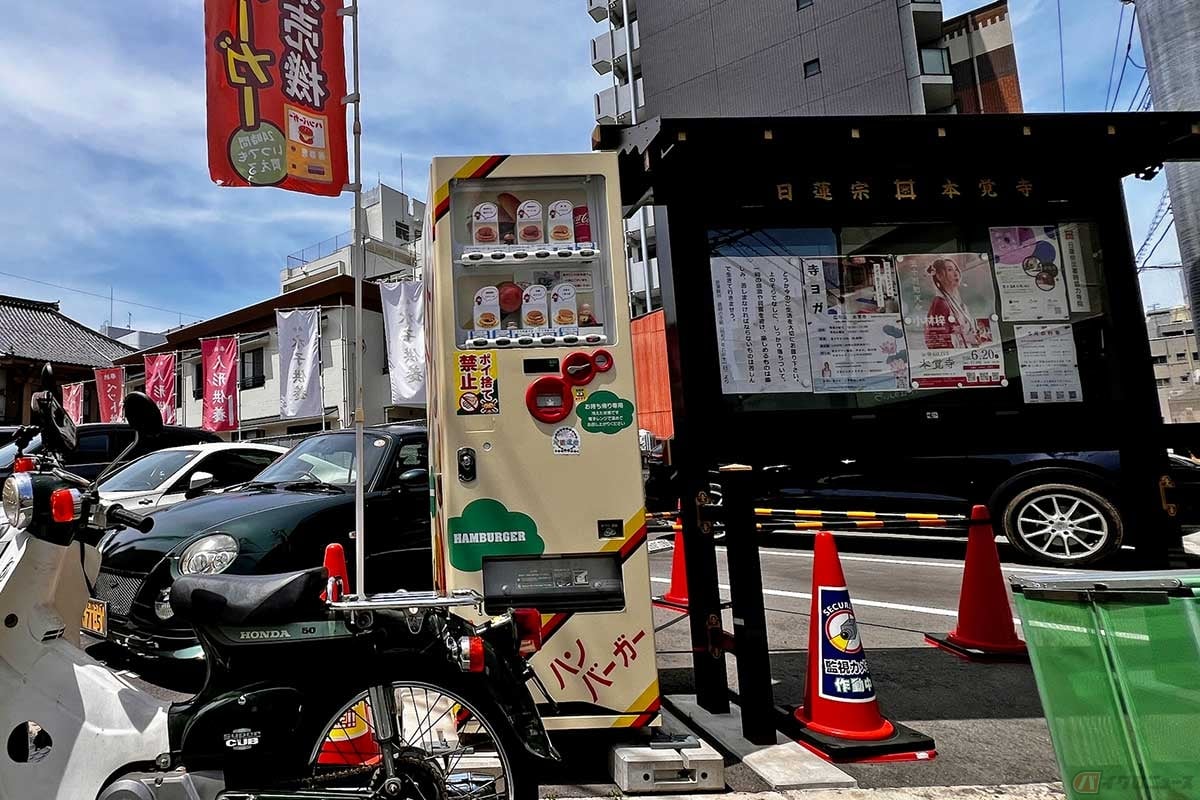 広島市内の「本覚寺」境内近くに設置されたハンバーガー自販機。隣には寺の掲示板という、少し変わった雰囲気が珍しい