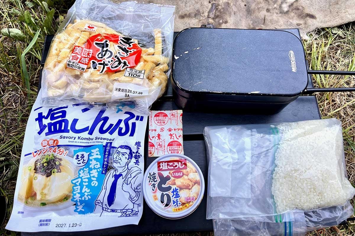いなば食品の「焼きとり 塩味」の缶詰、無洗米、油揚げ、塩昆布、和風だしを用意。メスティンを使って少ない材料で味わい深い炊き込みご飯ができる